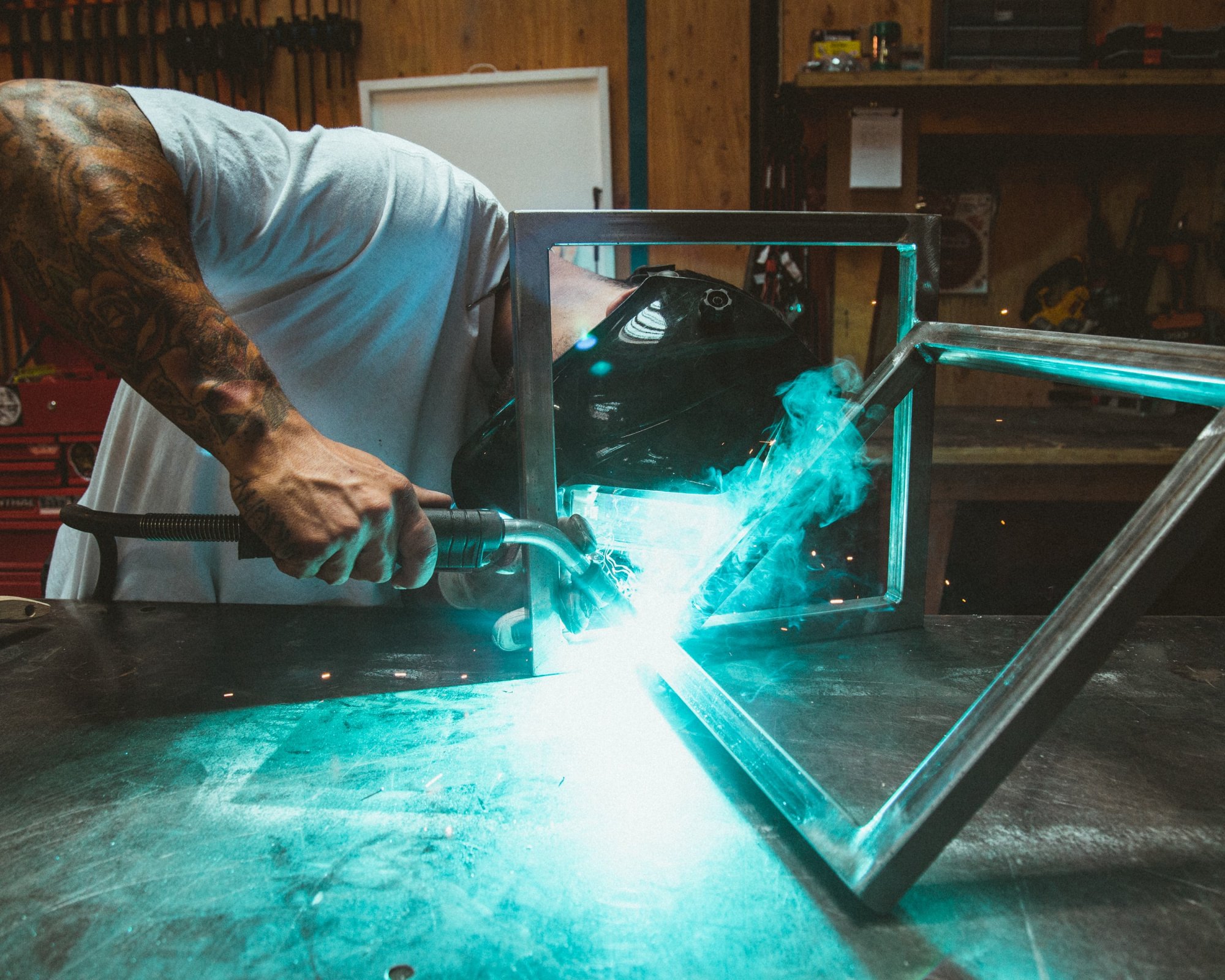 A man welding metal frames together.