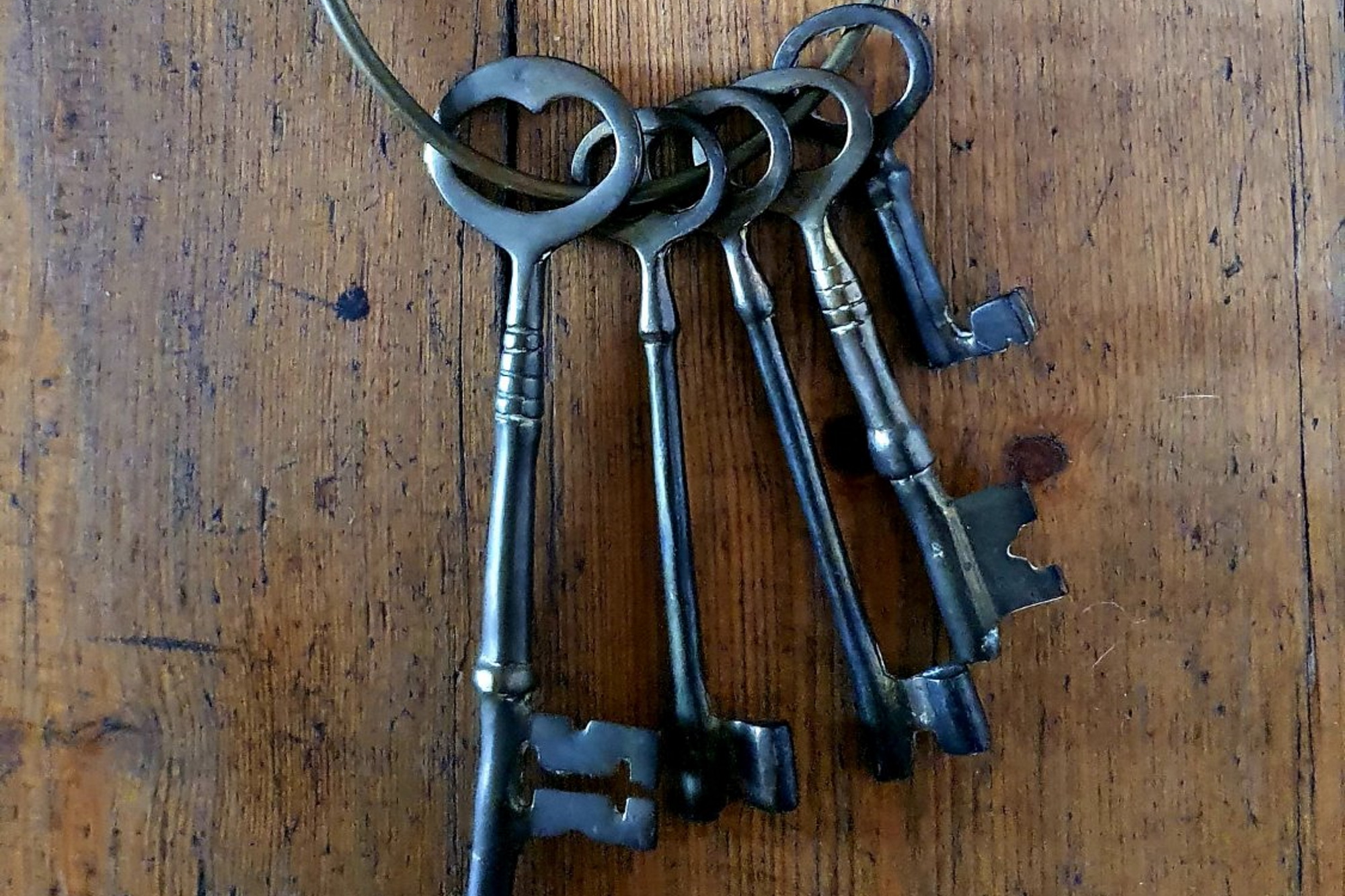 Old fashioned keys on a ring hanging on a door.